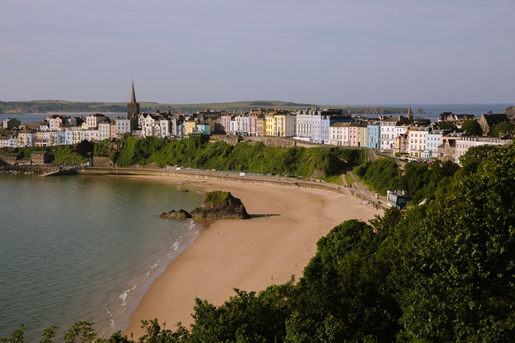 Pastel houses lined up in an arc by the seaside.