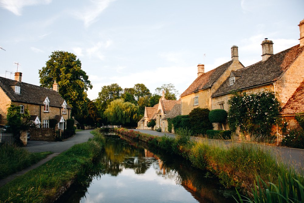 Old Cottages either side of a small reflective river