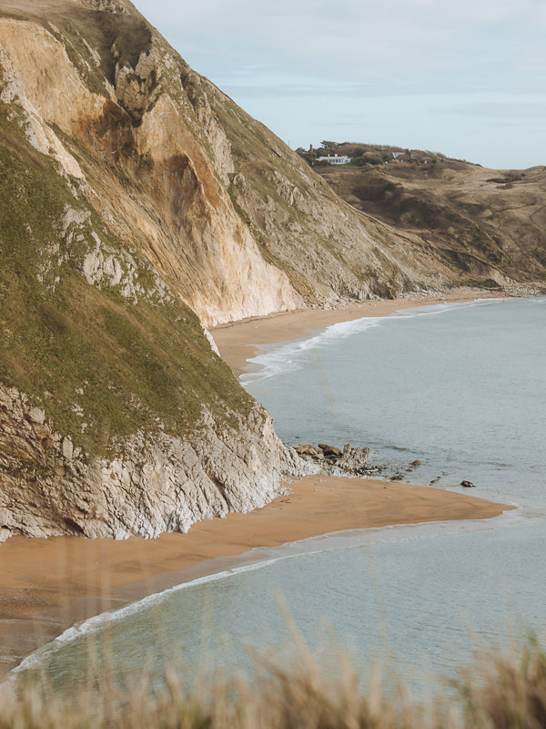 Secluded bay fringed by golden beaches and high cliffs