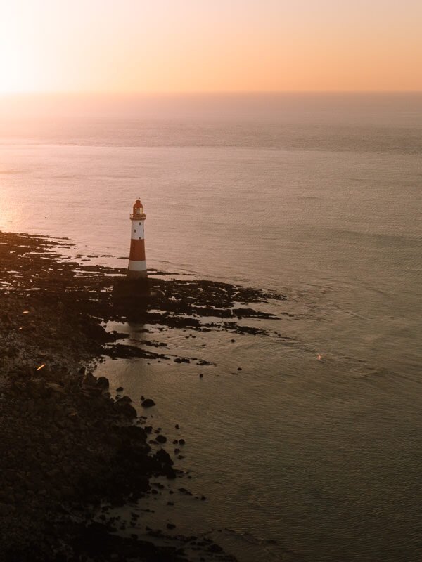 The Beachy Head lighthouse glowing in early morning light on the Seven Sisters walk near London