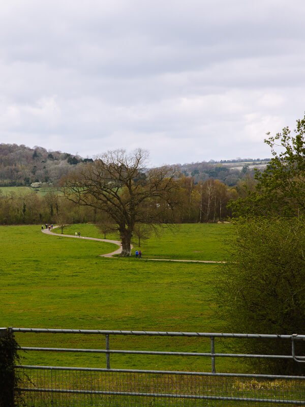A walking path curves through a green field on the Henley & Hambleden country walk near London