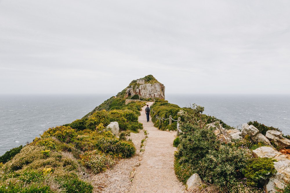 A walking path leading to a triangular rocky cliff