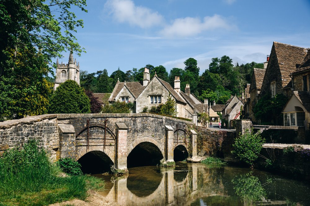 Old Cotswolds village houses in front of a stone bridge. Cotswolds villages