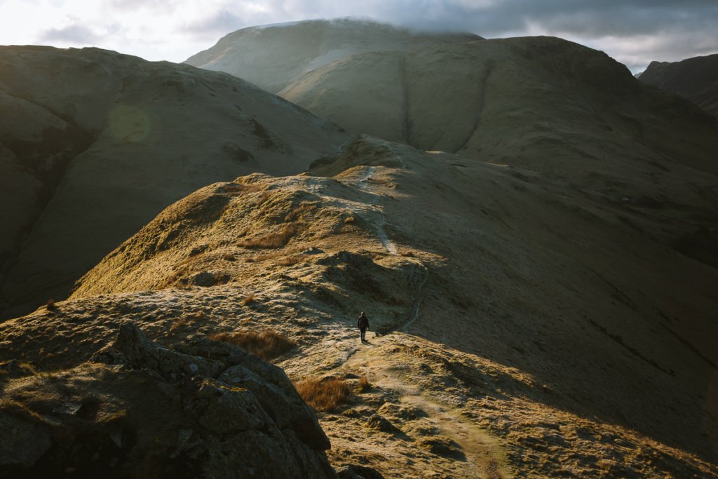 person walking on a huge mountain in morning light in the Lake District