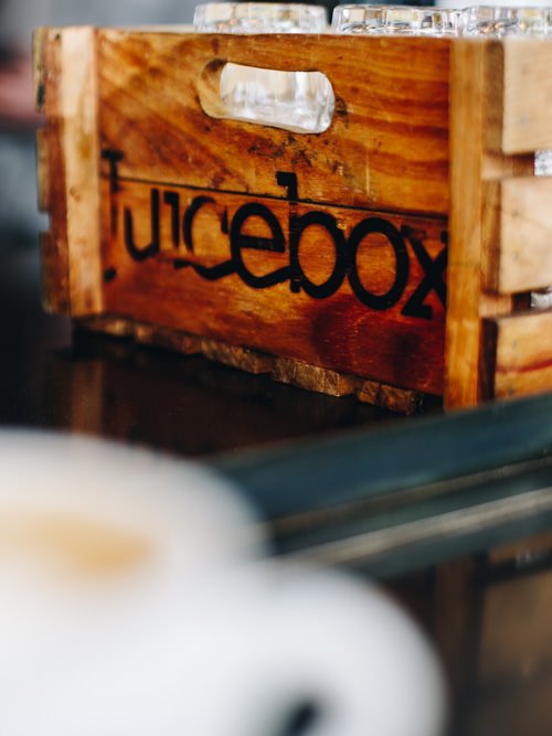 blurred coffee cup with "Juicebox" written on wooden box
