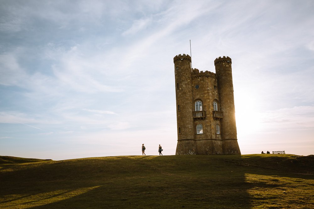 Tower folly on a hill backlit by the sunset